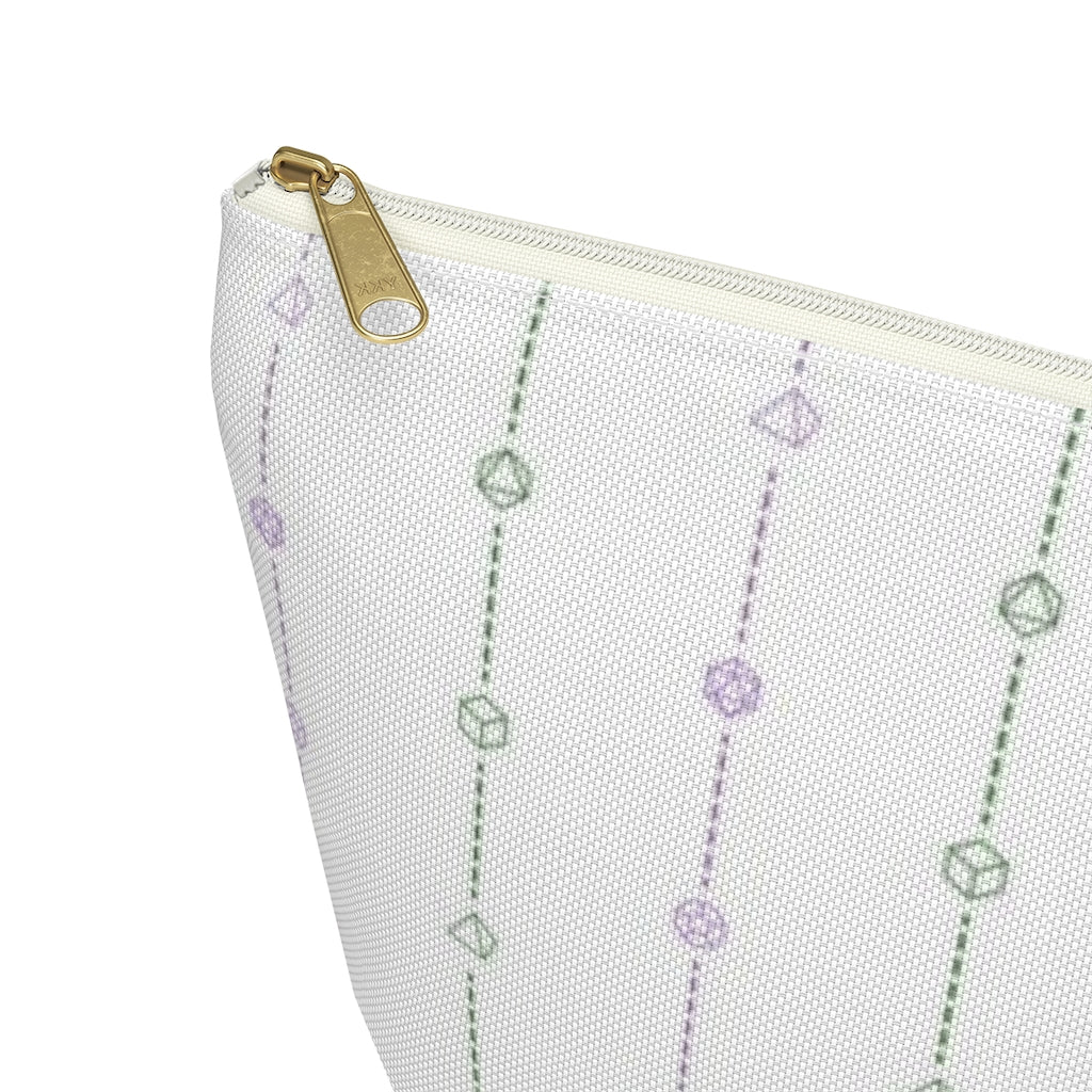 the large genderqueer dice t-bottom pouch corner detail on a white background. it's white with green and purple stripes of dashed lines and polyhedral dice and a gold zipper pull