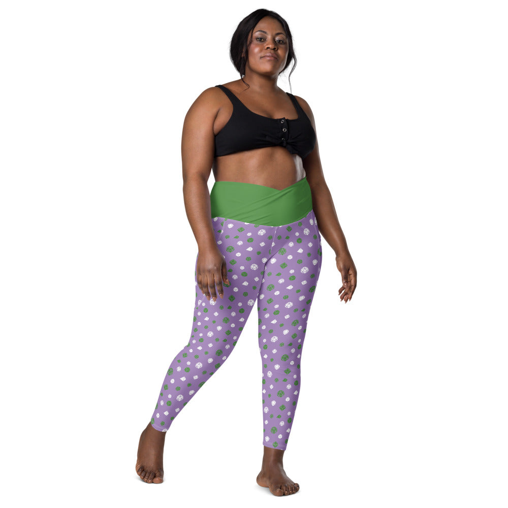 front view of dark-skinned female-presenting plus size model wearing the genderqueer dice leggings and a black sports bra. This view shows off the green crossover high-rise waistband
