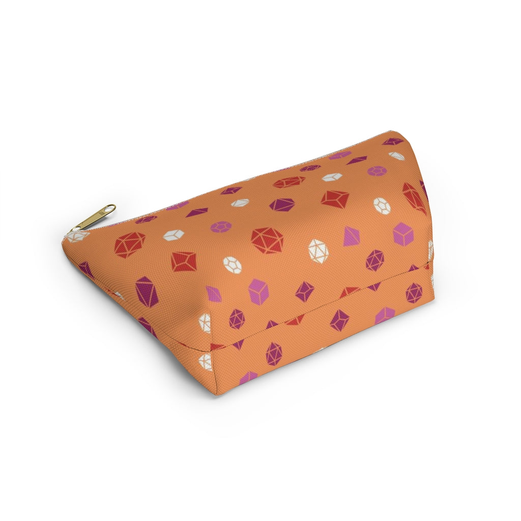 the small lesbian dice t-bottom pouch in bottom view on a white background. it's orange with pink, orange, and white polyhedral dice and a gold zipper pull