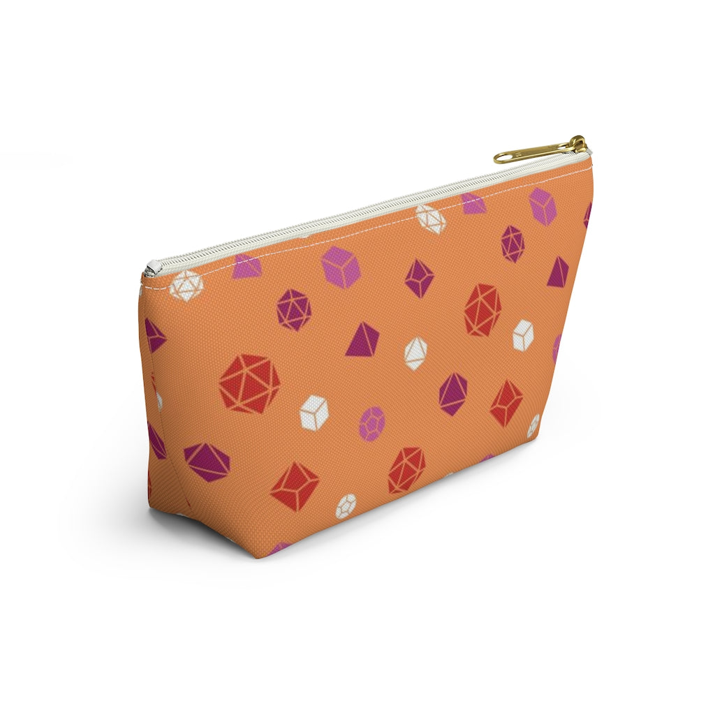 the small lesbian dice t-bottom pouch in side view on a white background. it's orange with pink, orange, and white polyhedral dice and a gold zipper pull