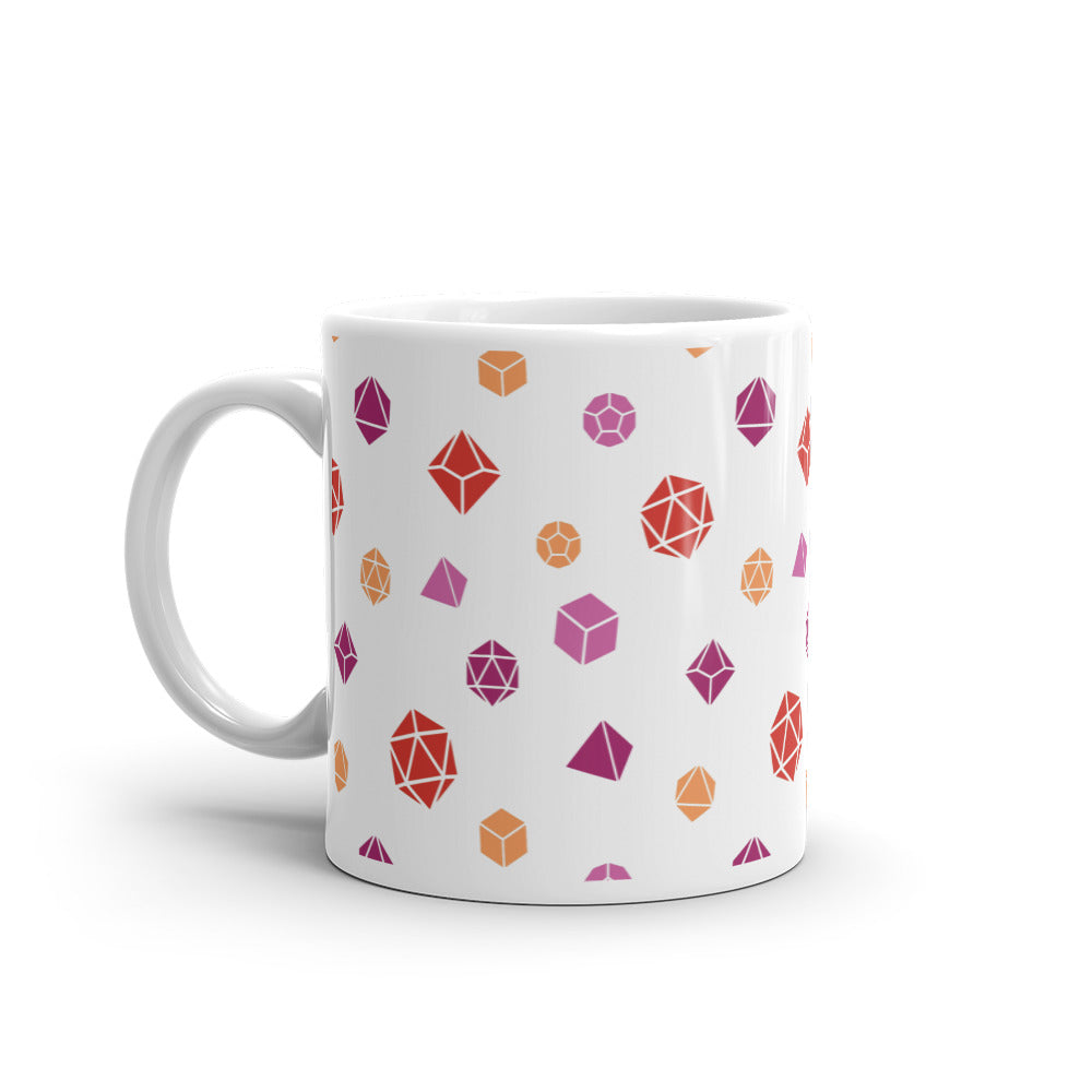 white mug on a white background with handle facing left. It has an all-over print of polyhedral d&d dice in the lesbian colors of pinks and oranges