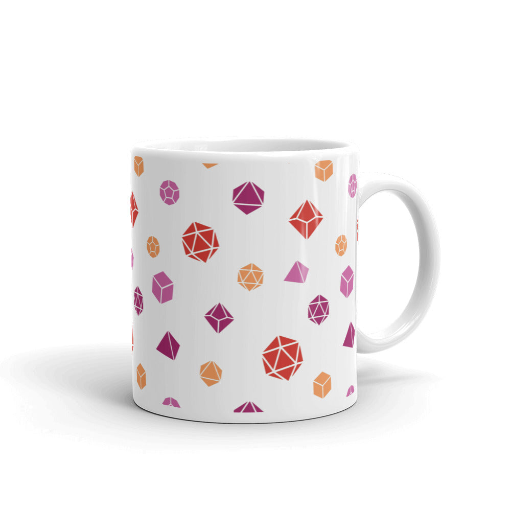 white mug on a white background with handle facing right. It has an all-over print of polyhedral d&d dice in the lesbian colors of oranges and pinks