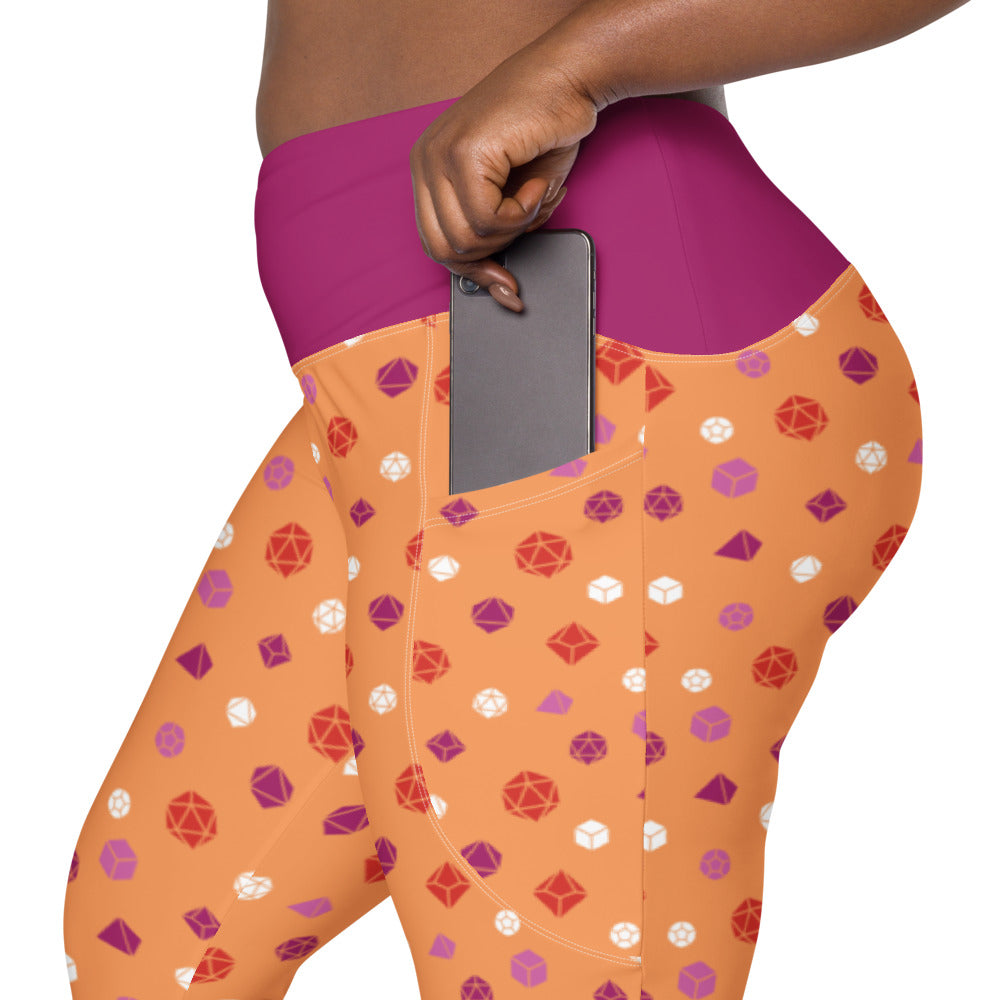 left side view of the lesbian dnd dice plus size leggings. the dark-skinned female-presenting model is sliding her phone into one of the side pockets