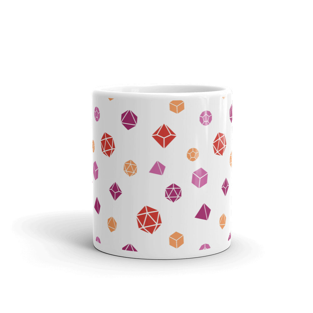 white mug on a white background with handle facing back. It has an all-over print of polyhedral d&d dice in the lesbian colors of oranges and pinks