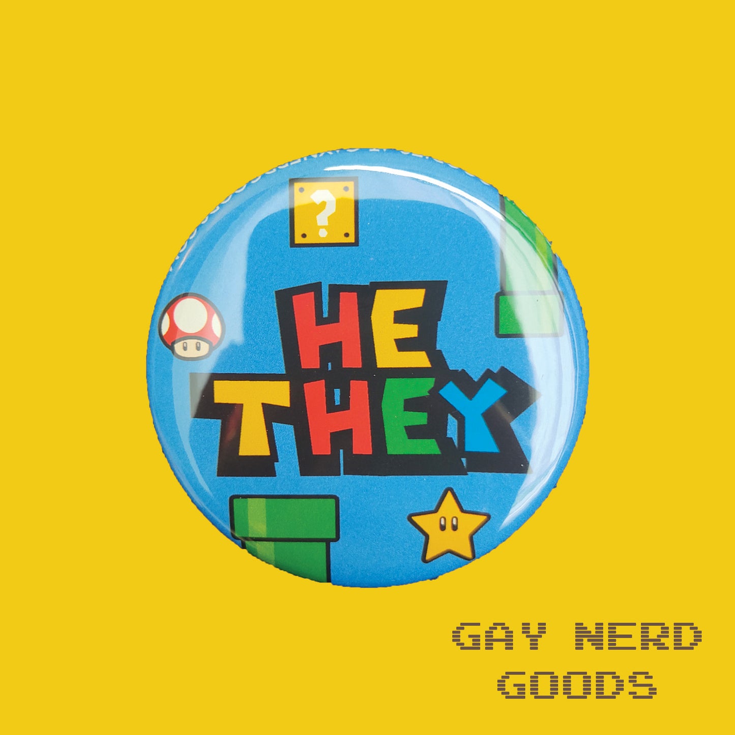 he they mario pronoun button with blue background, green pipes, question block, star, and mushroom on a yellow background