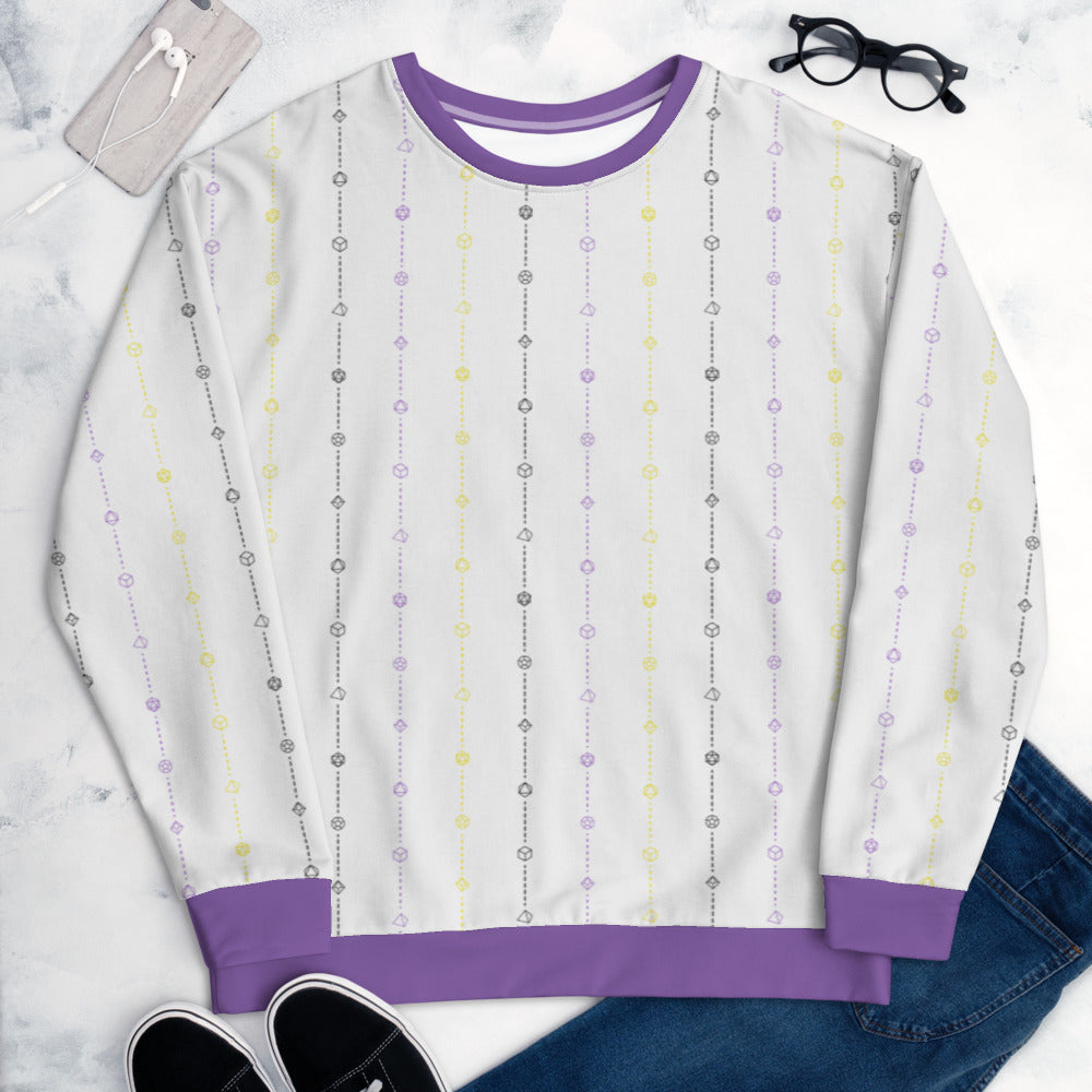 The nonbinary pride sweater laying flat, surrounded by clothes, a phone, and glasses. the sweater is white and has stripes of dashed lines and polyhedral dnd dice in purple, yellow, and black. The cuffs, collar, and waistband are a matching purple