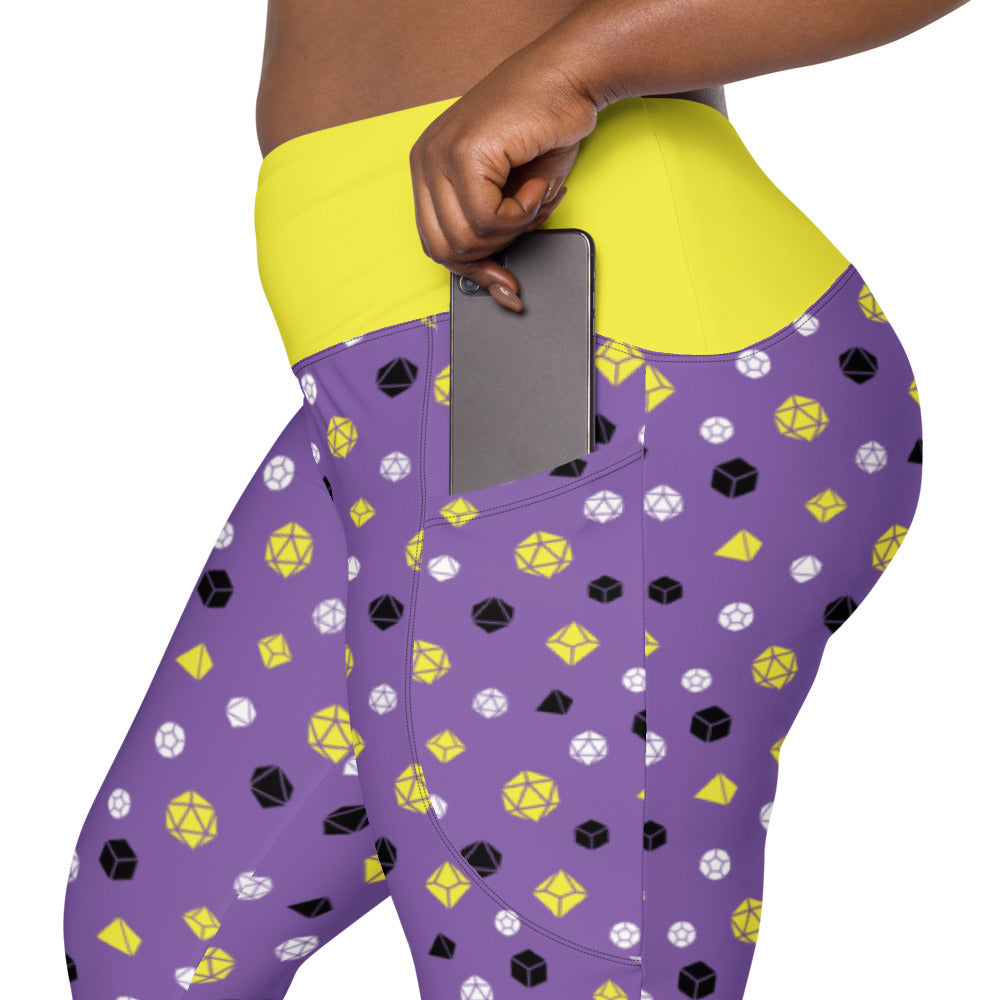 left side view of nonbinary dnd dice plus size leggings. the dark-skinned female-presenting model is sliding her phone into one of the side pockets