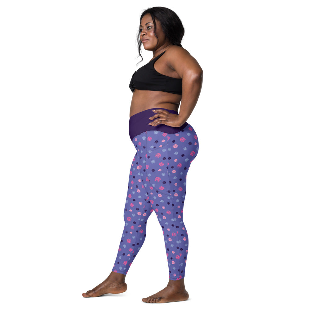 Left side view of dark-skinned female-presenting plus size model wearing the omnisexual dice leggings and black sports bra. She is facing left with her left hand on her hip and right leg forward