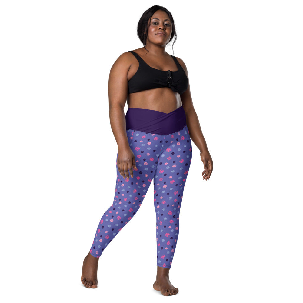 front view of dark-skinned female-presenting plus size model wearing omnisexual dice leggings and a black sports bra. This view shows off the purple crossover high-rise waistband