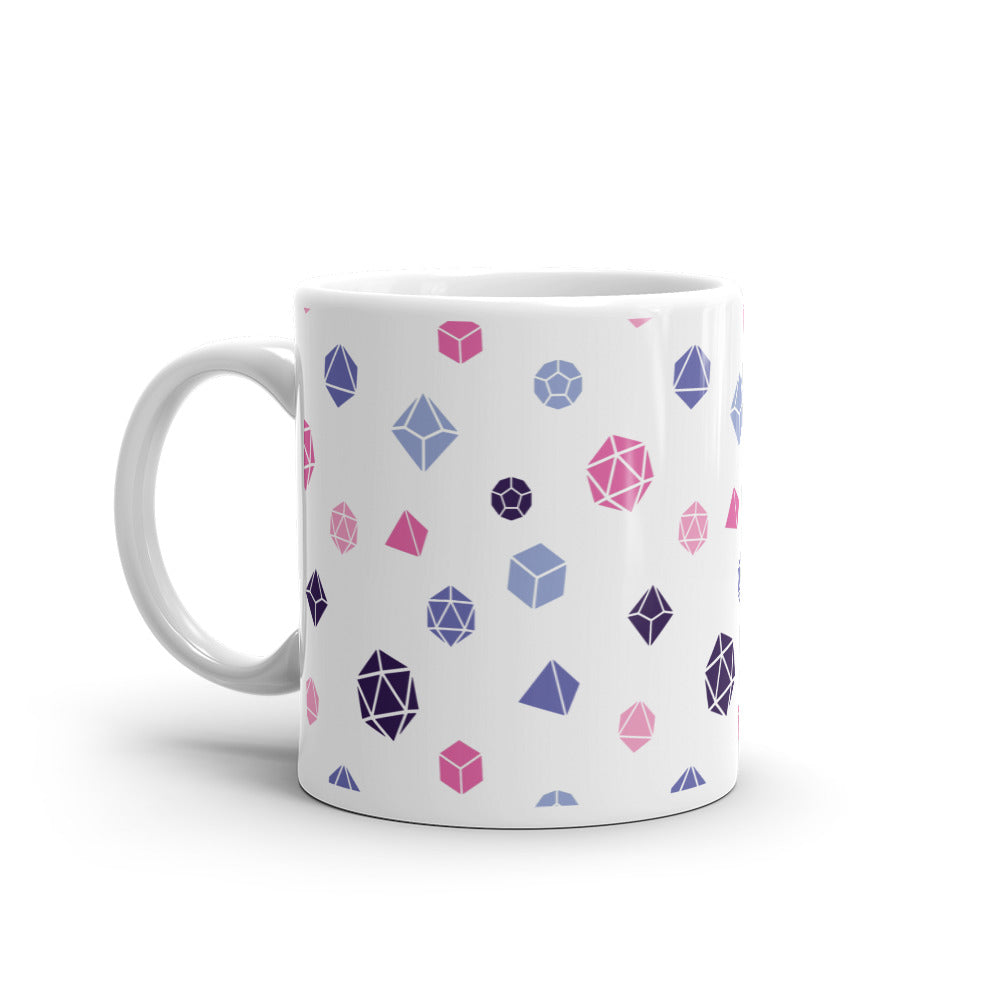 white mug on a white background with handle facing left. It has an all-over print of polyhedral d&d dice in the omnisexual colors of pinks, blues, and dark purple