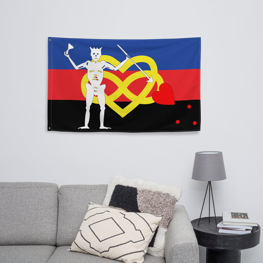 the polyamorous blackbeard pride flag hanging on a white wall above a couch and side table