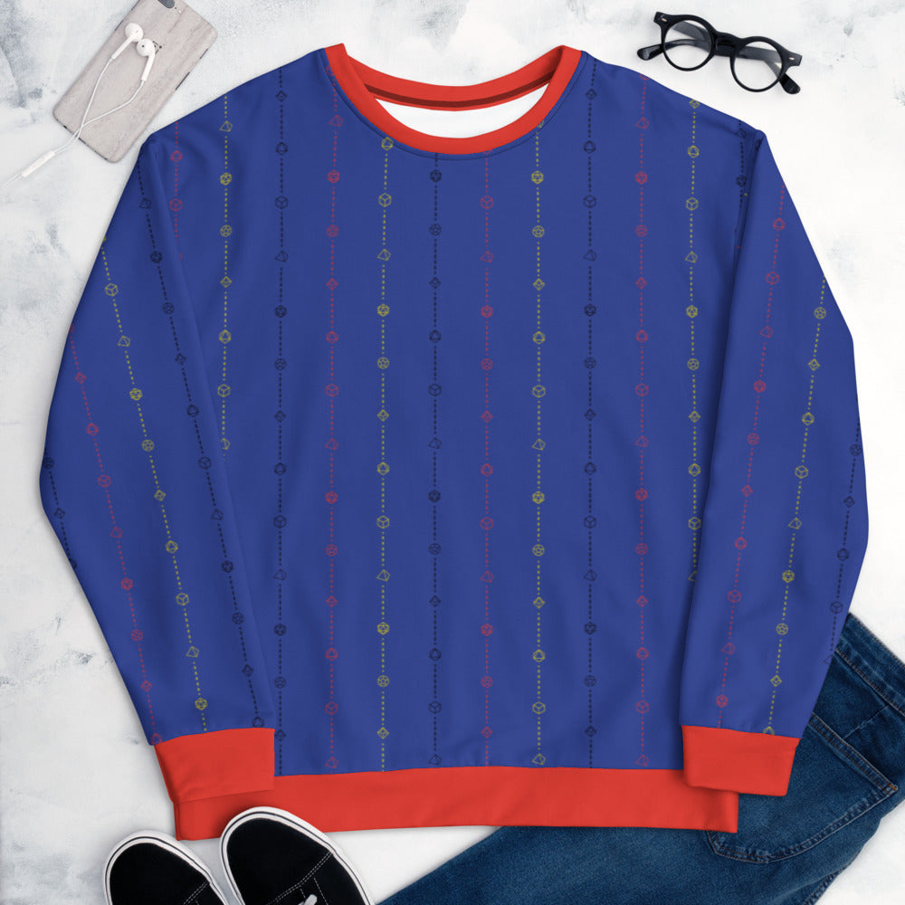 The polyamorous pride sweater laying flat, surrounded by clothes, a phone, and glasses. the sweater is blue and has stripes of dashed lines and polyhedral dnd dice in yellow, black, and red. The cuffs, collar, and waistband are a matching red