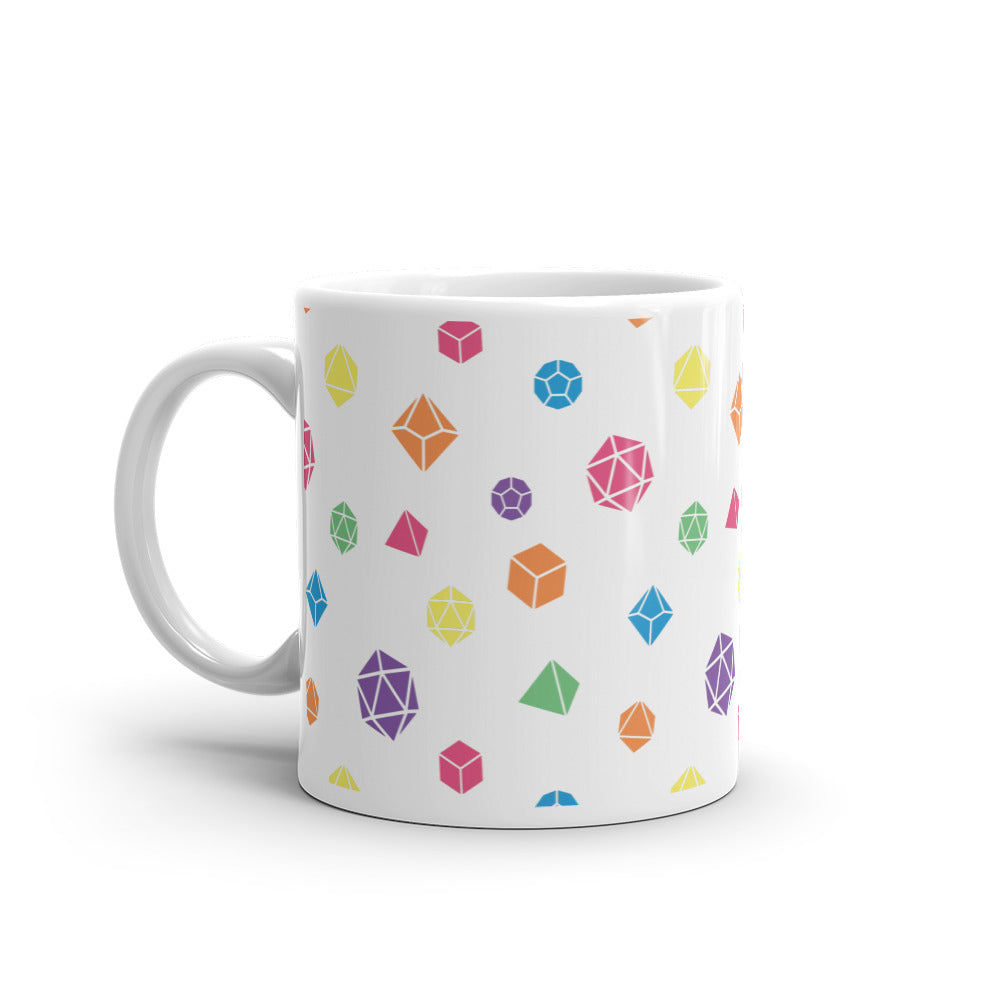 white mug on a white background with handle facing left. It has an all-over print of polyhedral d&d dice in rainbow colors