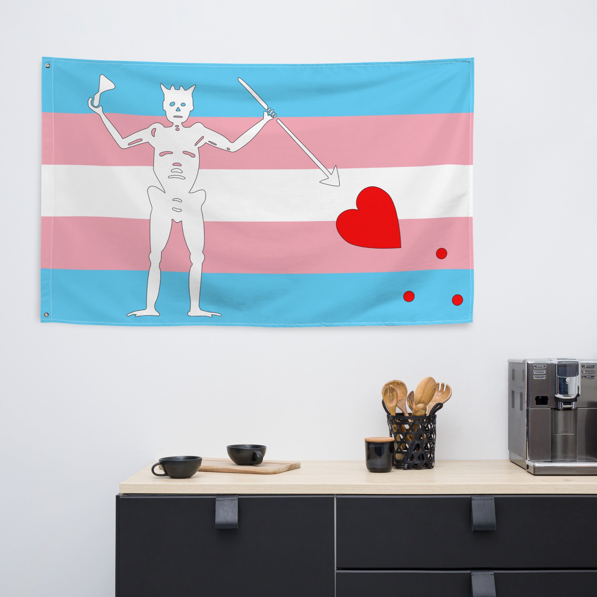 the transgender blackbeard pirate flag hanging on a white wall above a black kitchen counter