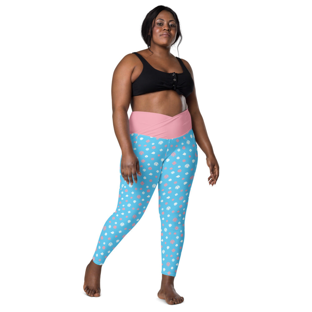 front view of dark-skinned female-presenting plus size model wearing transgender dice leggings and a black sports bra. This view shows off the pink crossover high-rise waistband