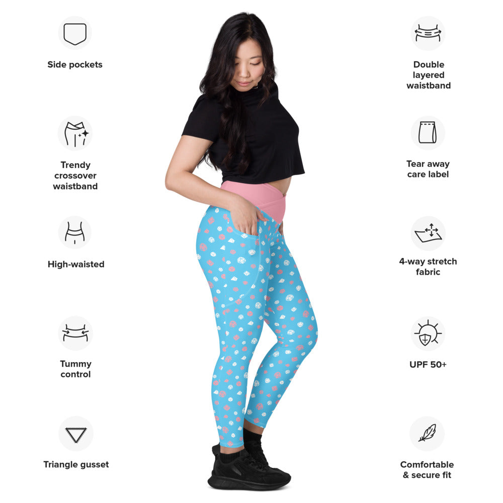 Light-skinned dark-haired female-presenting model wearing transgender dice leggings. she is facing right and has a hand in the pocket. she is surrounded by product specs: "side pockets, trendy crossover waistband, high-waisted, tummy control, triangle gusset, double layered waistband, tear away care label, 4-way stretch fabric, UPF 50+, comfortable & secure fit