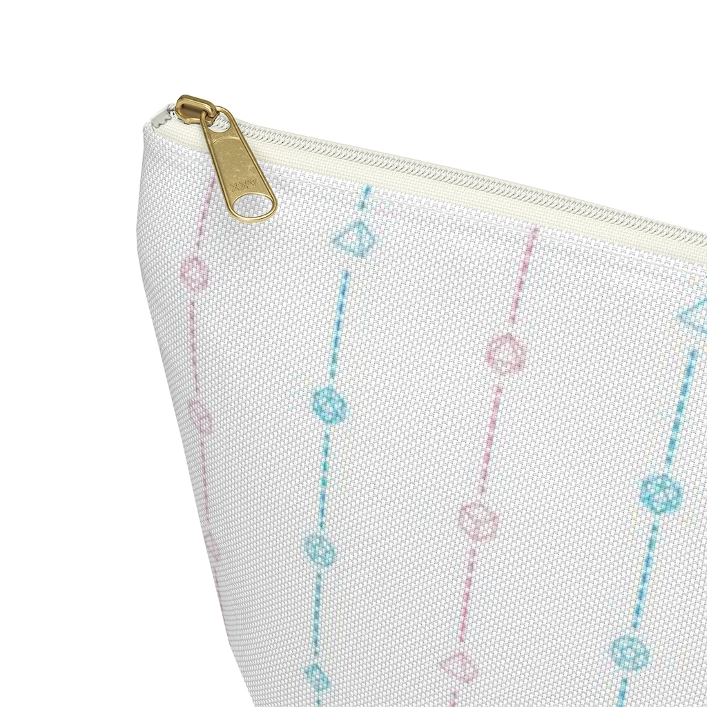 the small trans dice t-bottom pouch zoomed to show the zipper on a white background. it's white with pink and blue stripes of dashed lines and polyhedral dice and a gold zipper pull