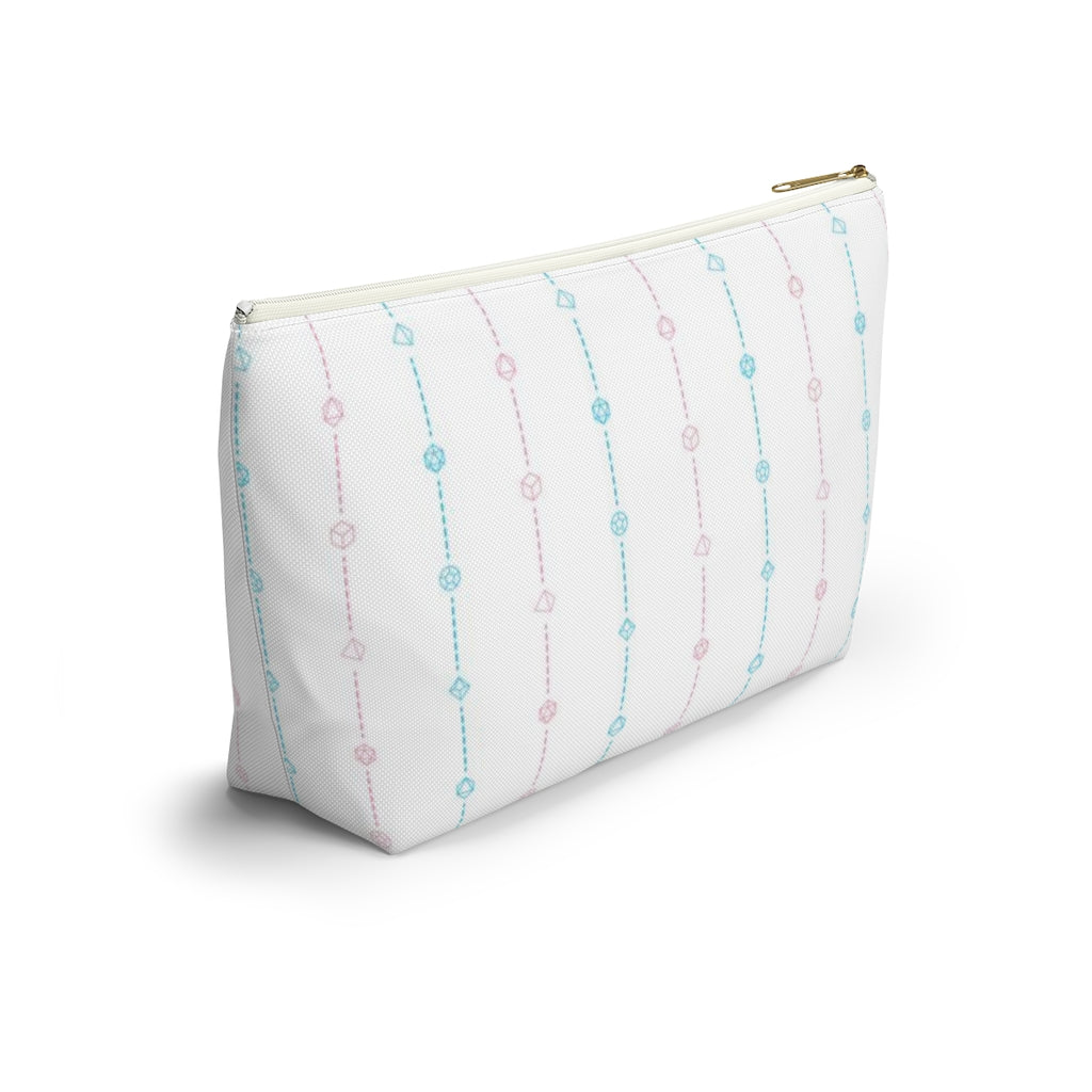 the small trans dice t-bottom pouch from the side on a white background. it's white with pink and blue stripes of dashed lines and polyhedral dice and a gold zipper pull